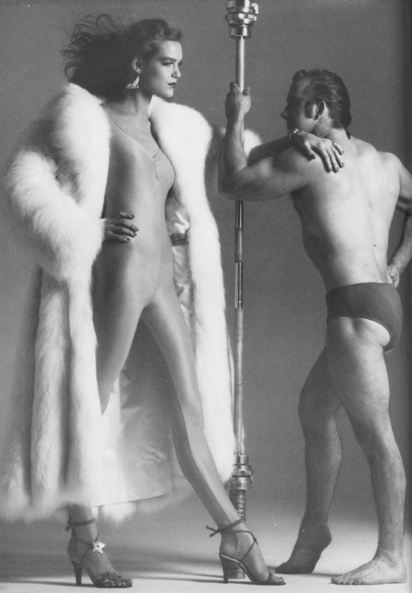 Coat by Andrea Daimond. Yellow bodysuit by Fiorucci. Purple leather shoes by Manolo Blahnik.