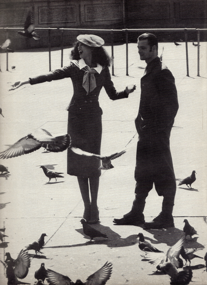 She: Red beret by Kangol. White blouse with red velvet ribbon tie by Sheridan Barnett at Quorum. Grey fleck suit by Strawberry Studio. Snakeskin strappy shoes by Sacha. Scarf from Essenses. He: Army jacket and trousers from Laurence Corner. Boots from Badges and Equipment.