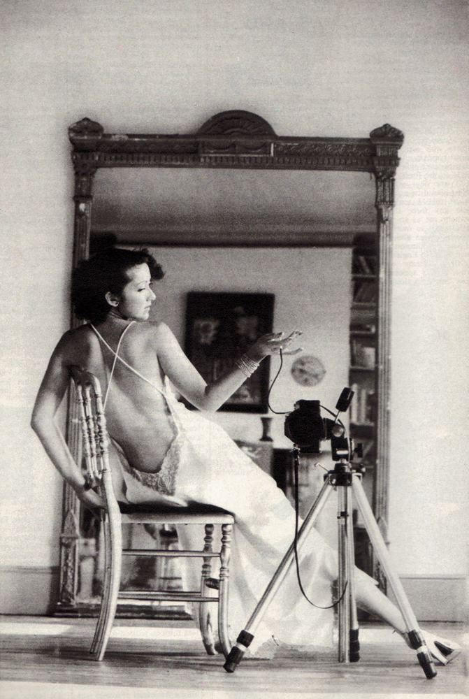 White satin nightdress by Janet Reger. White silk stockings from Wardrobe. Gold leather shoes from Russell and Bromley.