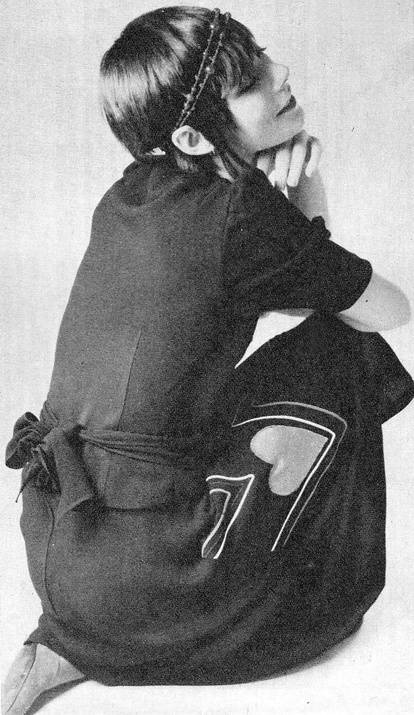 Black crepe skirt and jacket with tie in the back by Bus Stop. Red shoes by Sacha. Van der Fransen rope around head.