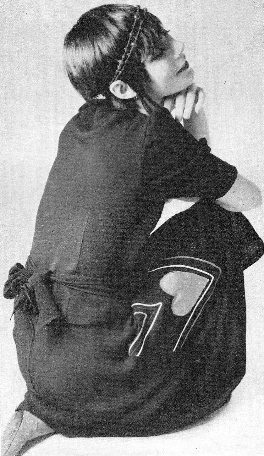 Black crepe skirt and jacket with tie in the back by Bus Stop. Red shoes by Sacha. Van der Fransen rope around head.