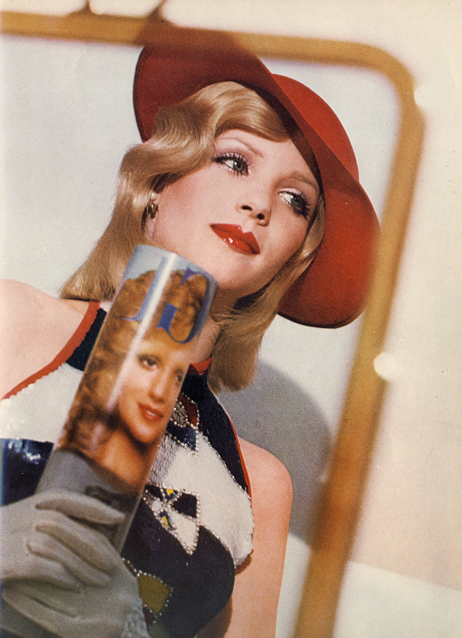 The shallow red straw hat by Herbert Johnson. Sequined halter top of flags flying and stripes by Walter Albini. White loves by Kir. Hair by Jean Louis David, Paris.